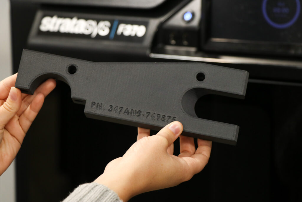 hands holding the abs-cf10 alignment fixture in front of F370 3d printer